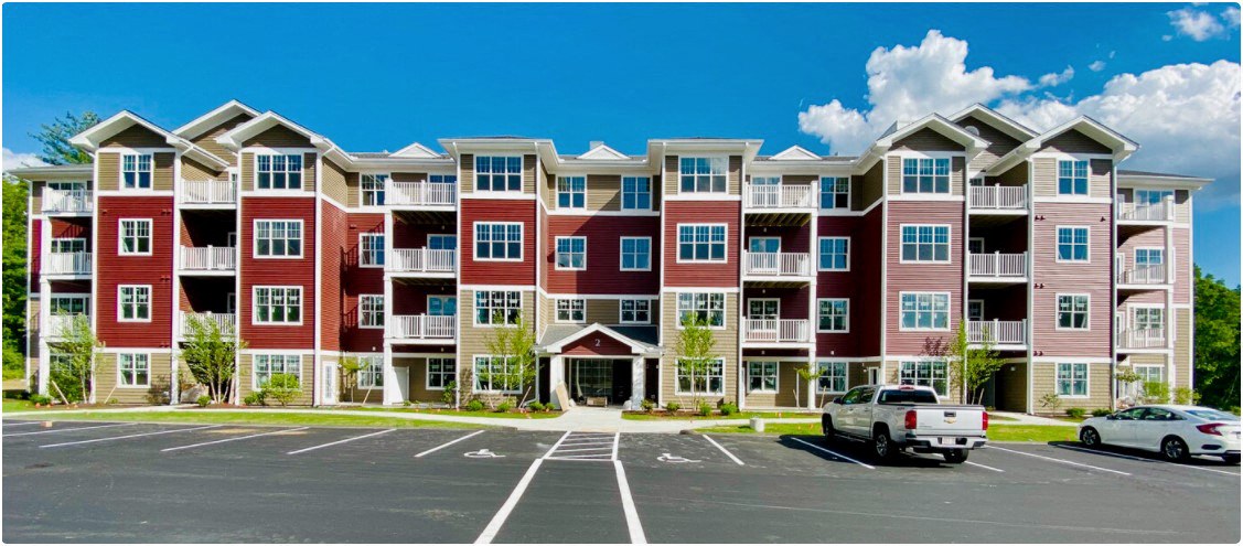 a large apartment building with cars parked in a parking lot